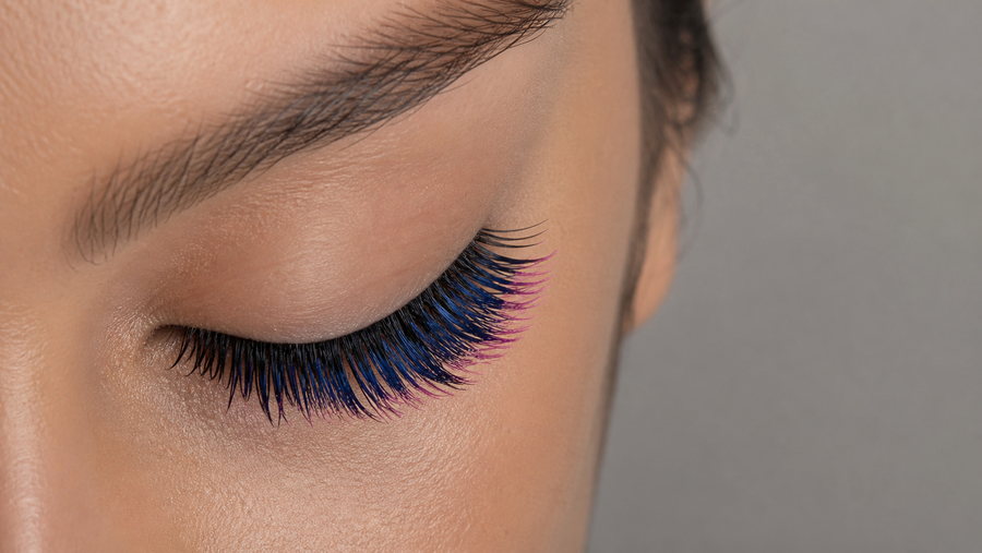 Close-up of a professional wet and wispy lash set with blue fibers and pink tips arranged as separated textured points.