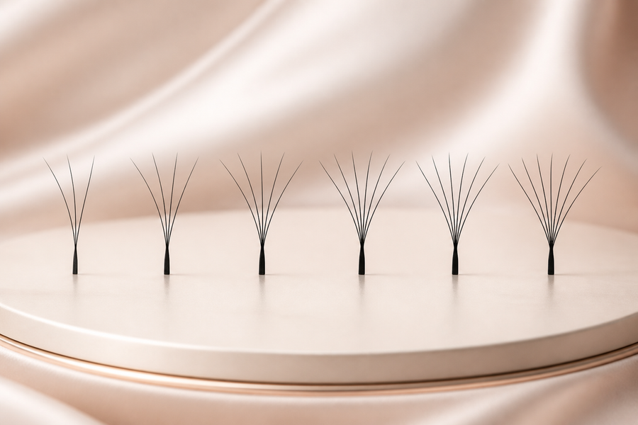 Six individual W lash units arranged from 3D to 8D on a champagne beauty display.